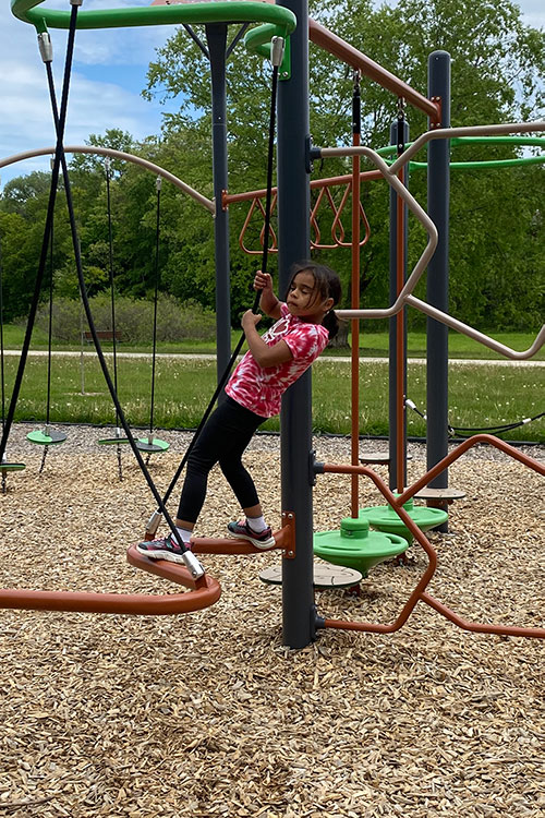 Girl playing on playground equipment